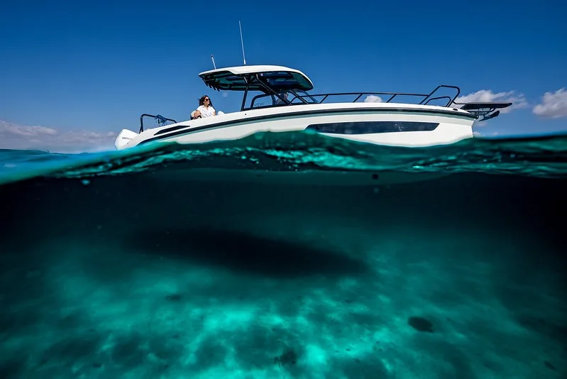 Split-level view of the NAVAN S30 at anchor with the sandy seabed glowing below the waterline