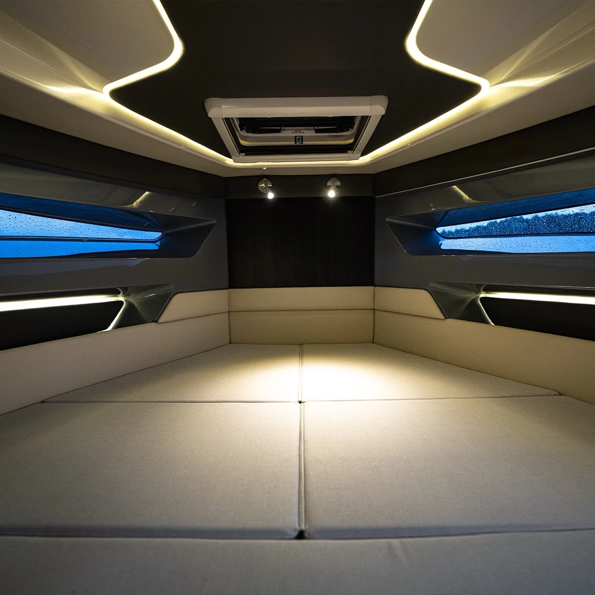 Kleine Doppelkabine unter Deck der NAVAN S30 mit cremefarbenen Polstern und Rumpffenstern