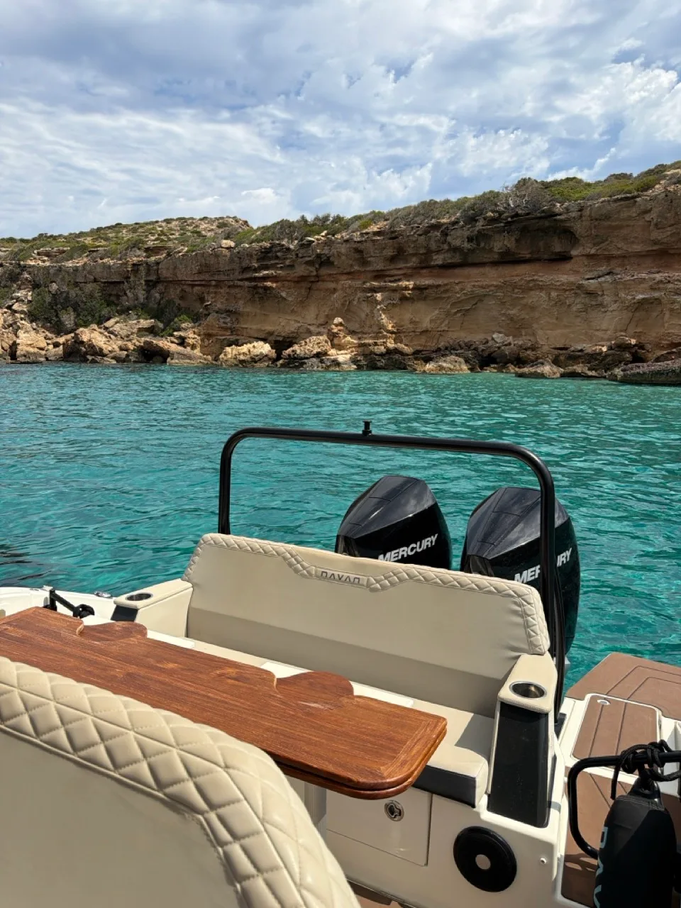 Aft deck of the NAVAN S30 with teak table against turquoise water