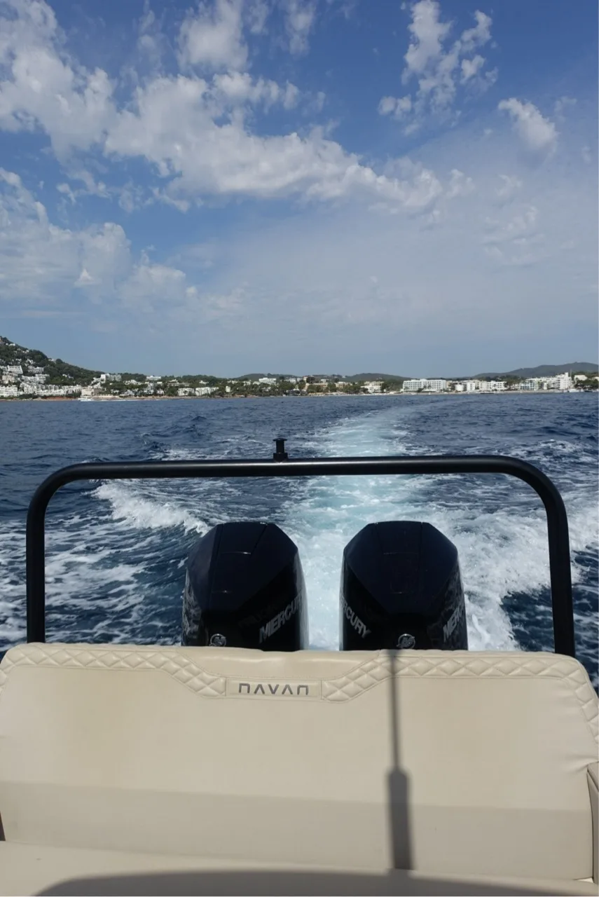 White wake behind the NAVAN S30 as the Santa Eulalia coastline recedes